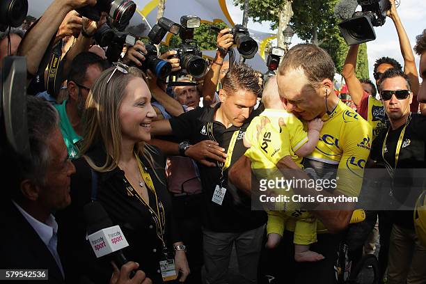 Chris Froome of Great Britain and Team Sky celebrates victory with his family as he is surrounded by the media during stage twenty one of the 2016 Le...