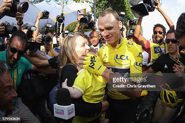 Chris Froome of Great Britain and Team Sky celebrates victory with his family as he is surrounded by the media during stage twenty one of the 2016 Le...