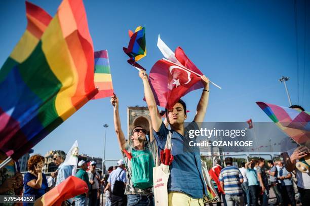 People wave LGBT rainbow flags at Istanbul's Taksim Square as they take part in a political demonstration on July 24, 2016. Many thousands of...