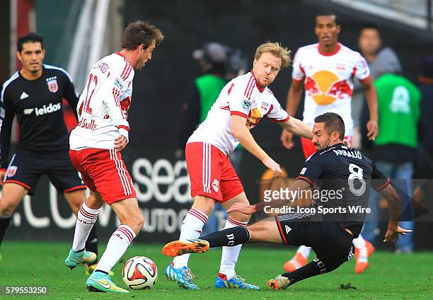 United midfielder Davy Arnaud defends against New York Red Bulls midfielder Dax McCarty and midfielder Eric Alexander during the MLS Eastern...