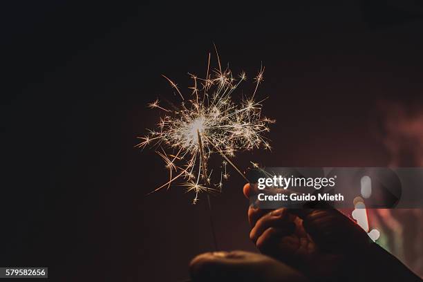 woman holding sparkler. - sparkler stock-fotos und bilder