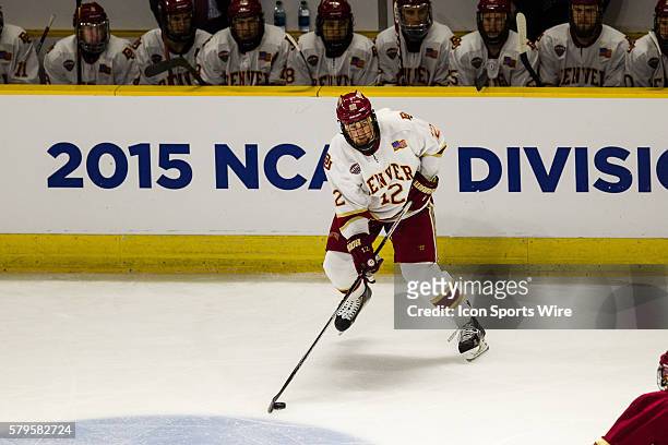University of Denver Forward Ty Loney plays the puck in front of the Denver bench during the first round of the 2015 NCAA East Regional game between...