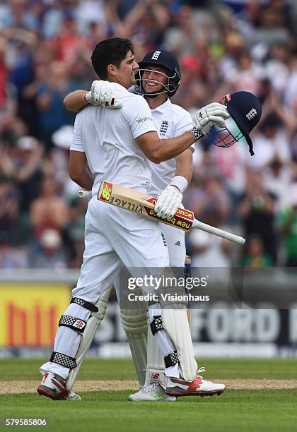 Joe Root of England congratulates team mate Alastair Cook after scoring a century during the first day of the second test between England and...