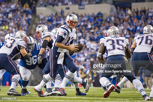 New England Patriots quarterback Tom Brady drops back to hand off to New England Patriots running back Jonas Gray during a football game between the...