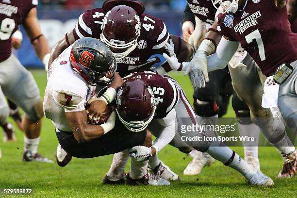 North Carolina State Wolfpack wide receiver Nyheim Hines is wrapped up by Mississippi State Bulldogs defensive lineman A.J. Jefferson and linebacker...