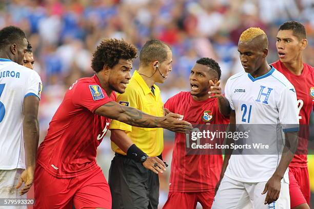 Panama midfielder Alberto Quintero complains to the ref with teammate Panama defender Roman Torres as Honduras defender Brayan Beckeles watches on....