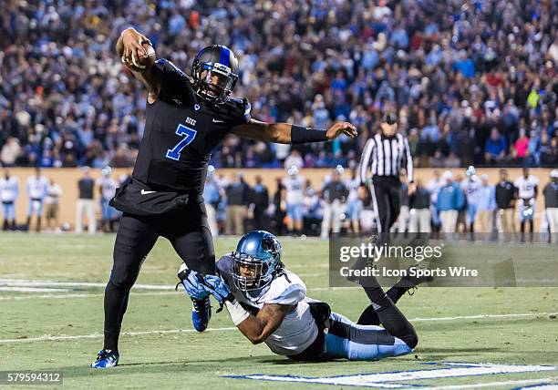 Duke Blue Devils quarterback Anthony Boone tries to escape the tackle of University of North Carolina Tar Heels defender Tim Scott during the game...