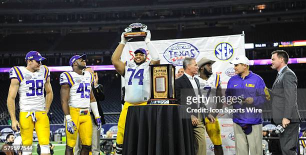 Tigers offensive tackle Vadal Alexander hoists the winners trophy over his head following the 2015 Advocare Texas Bowl featuring the LSU Tigers vs...
