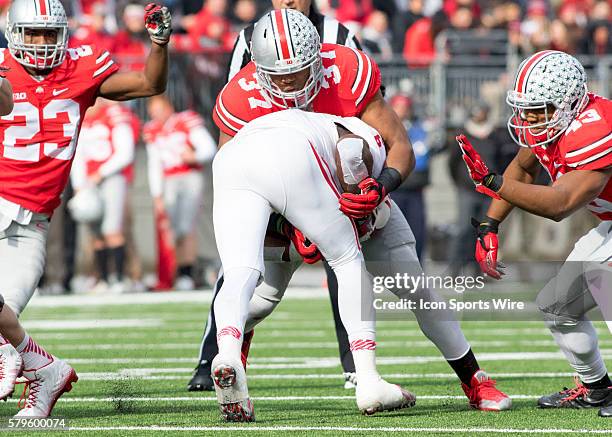 Linebacker Joshua Perry of the Ohio State Buckeyes tackling running back Tevin Coleman of the Indiana Hoosiers during the game between the Ohio State...