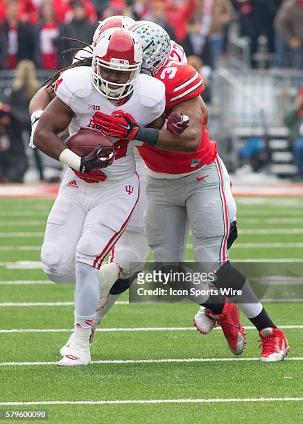 Running back Devine Redding of the Indiana Hoosiers being talcing by linebacker Joshua Perry of the Ohio State Buckeyes during the game between the...