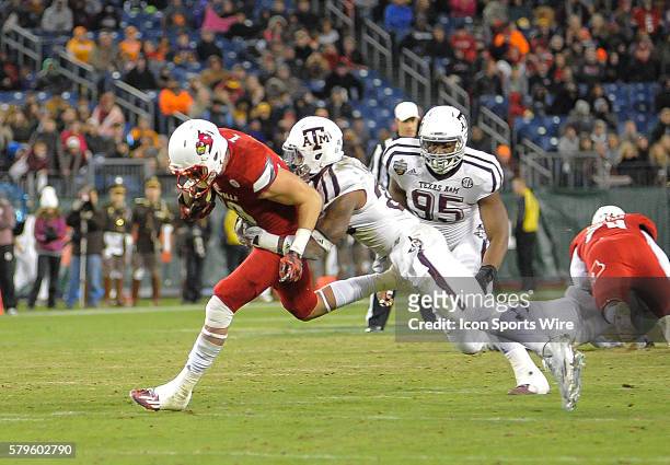 Louisville Cardinals tight end Cole Hikutini drags Texas A&M Aggies defensive back Armani Watts during an college football game between the...