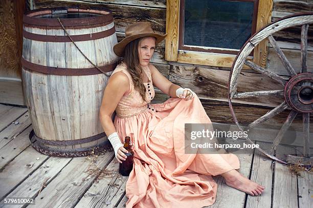 cowgirl with a beer and cigar. - wagon wheel stock pictures, royalty-free photos & images