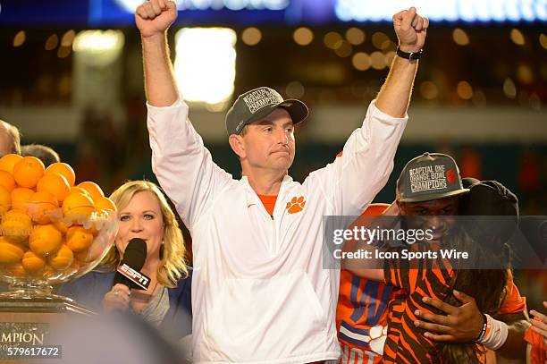 Clemson Tigers Head Coach Dabo Swinney raises his arms as his wife, Kathleen Swinney hugs Clemson Tigers Quarterback Deshaun Watson as they celebrate...