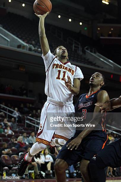 Trojan Jordan McLaughlin goes up for the layup past Cal State Fullerton's Moses Morgan during the game at the Galen Center in Los Angeles, CA.