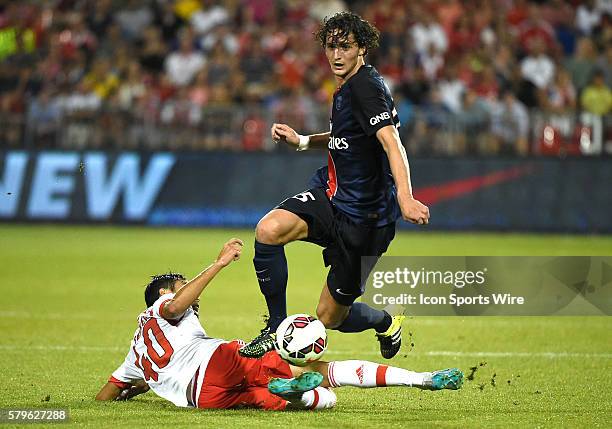 Paris St. Germain midfielder Adrien Rabiot hurdles a sliding tackle from Benfica midfielder Joao Teixeira in the second half of an International...