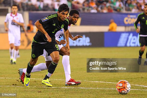 Mexico midfielder Jesus Corona puts the ball through the legs of Costa Rica defender Dave Myrie during the second half of the CONCACAF Gold Cup...