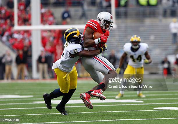 Ohio State Buckeyes wide receiver Michael Thomas makes the catch as Michigan Wolverines defensive back Raymon Taylor attempts to make the tackle...