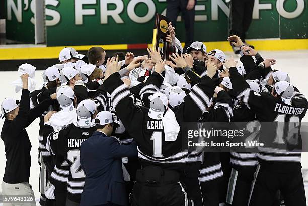Providence gathers around the NCAA Men's Div 1 trophy. The Providence College Friars defeated the Boston University Terriers 4-3 in the final of the...