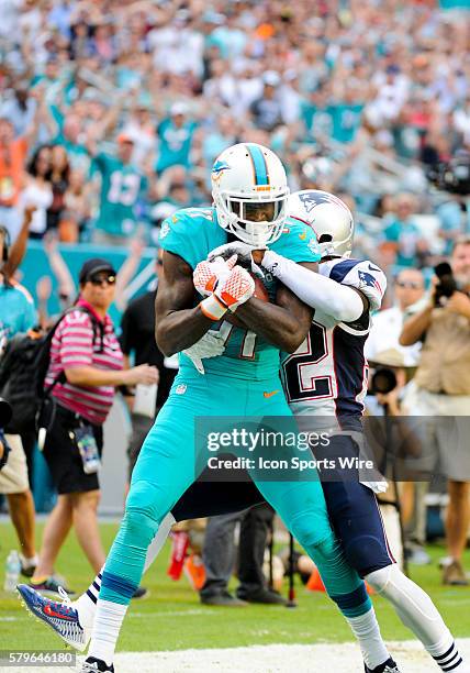 Miami Dolphins Wide Receiver DeVante Parker leaps in the air to juggle the ball and then finally make the reception as New England Patriots...