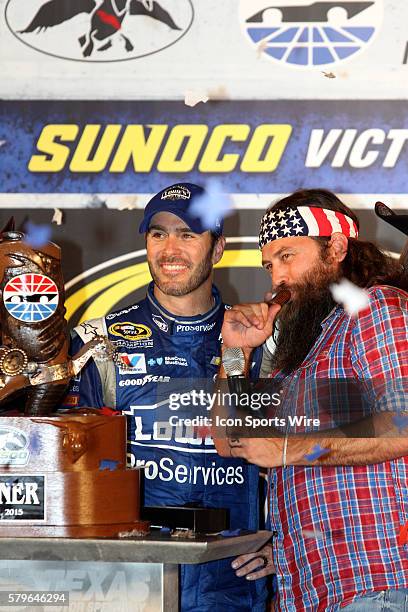 Willie Robertson presents a duck call to Jimmie Johnson, winning driver of the NASCAR Sprint Cup Series Duck Commander 500 at Texas Motor Speedway in...