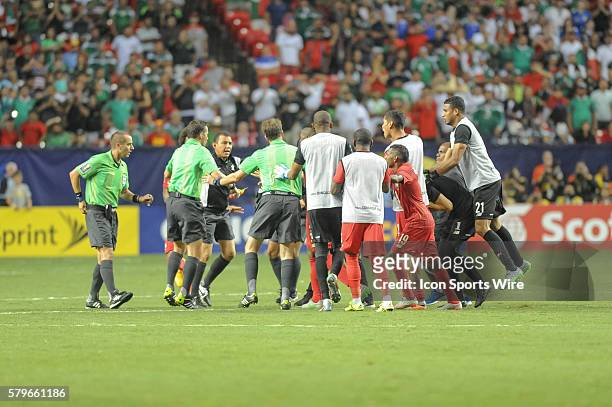 Referee Mark Geiger is escorted off the field by CONCACAF security after the CONCACAF semifinal match between the Panama and Mexico at the Georgia...