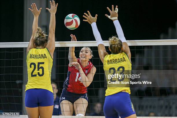 Nicole Fawcett (14 of the United States hits against Mariana Costa and Barbara Bruch of Brazil during the Women's Volleyball Gold Medal match at the...