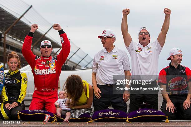 Kyle Busch, driver of the Skittles Toyota celebrates after kissing the bricks with his wife Samantha Busch, son Brexton Busch, Team Owners Joe and JD...