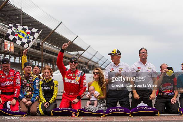 Kyle Busch, driver of the Skittles Toyota celebrates after kissing the bricks with his wife Samantha Busch, son Brexton Busch, Team Owners Joe and JD...