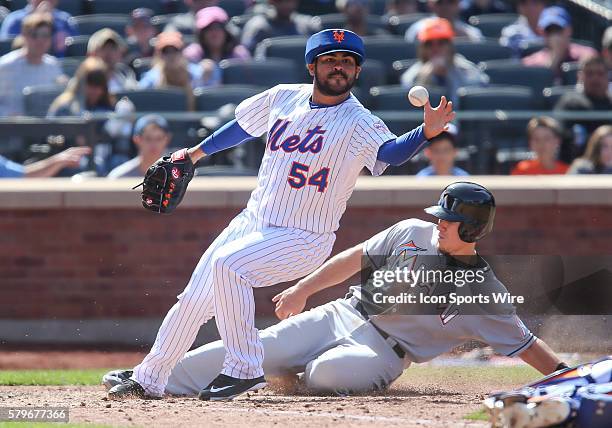 Miami Marlins Catcher J.T. Realmuto [8458] scores from third on a wild pitch by New York Mets Pitcher Alex Torres [3848], despite a diving play by...