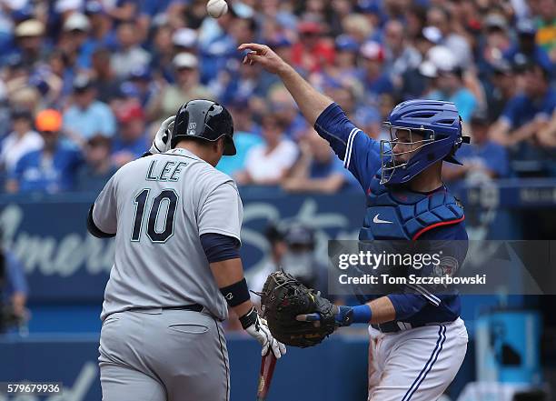 Dae-Ho Lee of the Seattle Mariners reacts after striking out in the seventh inning during MLB game action as Josh Thole of the Toronto Blue Jays...