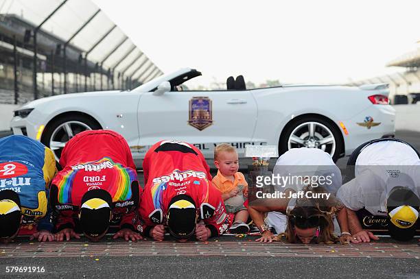 Kyle Busch, driver of the Skittles Toyota, kisses the bricks with his wife, Samantha, after winning the NASCAR Sprint Cup Series Crown Royal Presents...