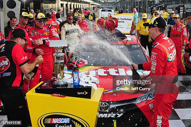 Kyle Busch, driver of the Skittles Toyota, celebrates with champagne in Victory Lane after winning the NASCAR Sprint Cup Series Crown Royal Presents...