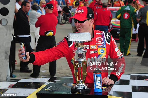 Kyle Busch, driver of the Skittles Toyota, poses in Victory Lane after winning the NASCAR Sprint Cup Series Crown Royal Presents the Combat Wounded...
