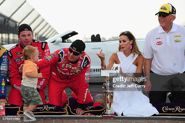 Kyle Busch, driver of the Skittles Toyota, celebrates with his wife, Samantha, son, Brexton, and team owner Joe Gibbs after winning the NASCAR Sprint...