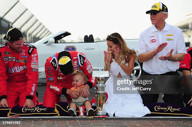 Kyle Busch, driver of the Skittles Toyota, celebrates with his wife, Samantha, son, Brexton, and team owner Joe Gibbs after winning the NASCAR Sprint...