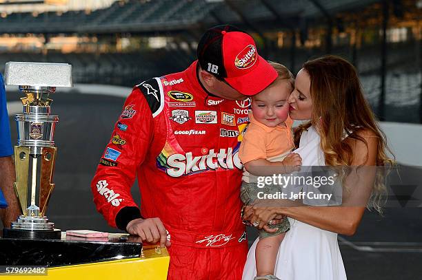 Kyle Busch, driver of the Skittles Toyota, celebrates with his wife, Samantha, and son, Brexton, after winning the NASCAR Sprint Cup Series Crown...