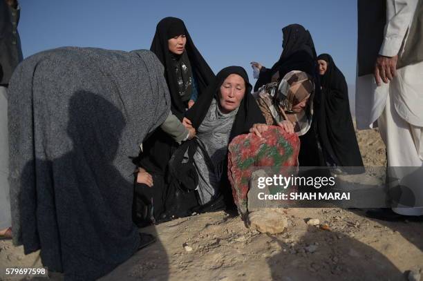 An elderly mother mourns at the grave of her son after he was killed in the July 23 twin suicide attack in Kabul on July 25, 2016. Kabul was plunged...