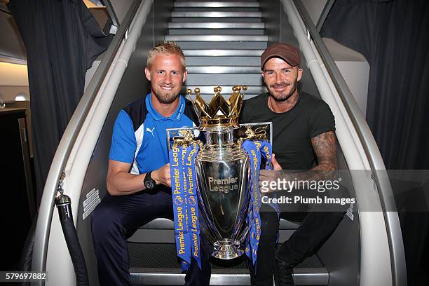 Leicester City's Kasper Schmeichel shows off the Premier League trophy to David Beckham on a B.A flight to Los Angeles as the Leicester City squad...
