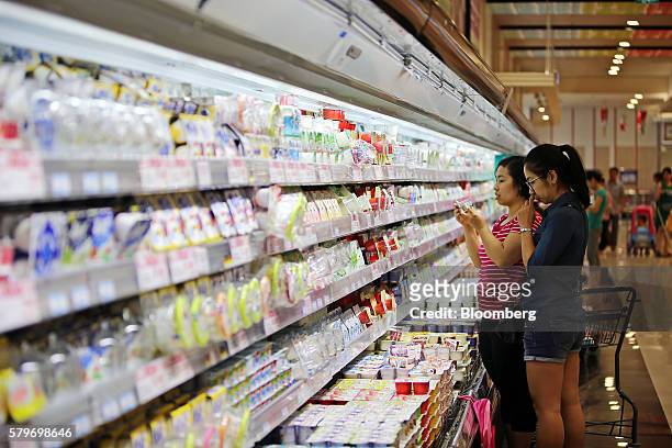 Shopper checks a yogurt carton at the Aeon Co. Mall in the Long Bien district of Hanoi, Vietnam, on Thursday, July 21, 2016. With a young population,...