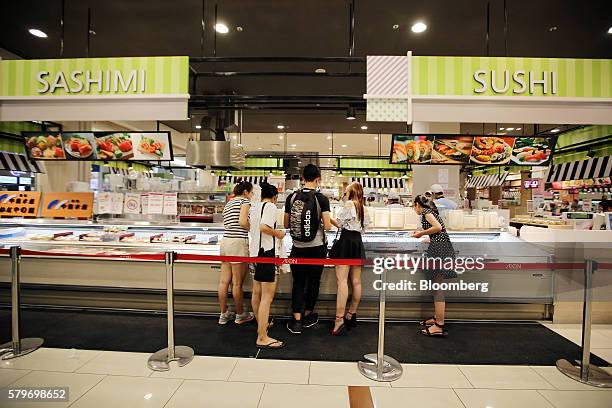 Shoppers browse sashimi and sushi at the Aeon Co. Mall in the Long Bien district of Hanoi, Vietnam, on Thursday, July 21, 2016. With a young...