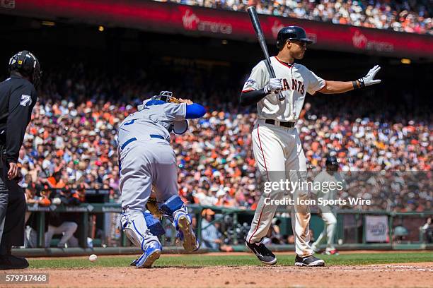 San Francisco Giants right fielder Justin Maxwell signals to hold as Los Angeles Dodgers catcher Yasmani Grandal chases the wild pouch, during a...