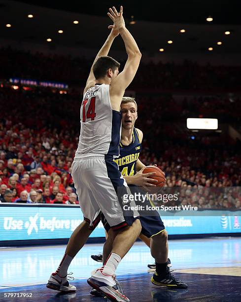 Michigan Wolverines forward Max Bielfeldt is defended by Arizona Wildcats center Dusan Ristic during the second half of the college basketball game...