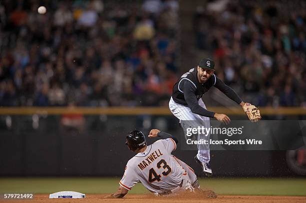 Colorado Rockies shortstop Daniel Descalso leaps over a sliding San Francisco Giants right fielder Justin Maxwell for a double play during a regular...