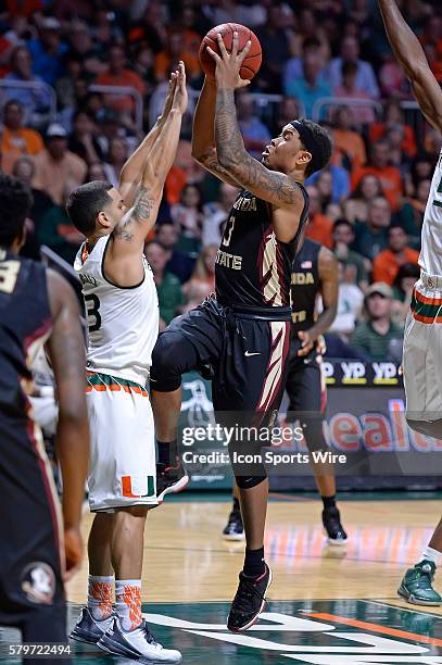 Florida State guard Benji Bell puts up a basket over Miami guard Angel Rodriguez in the first half as the University of Miami Hurricanes defeated the...