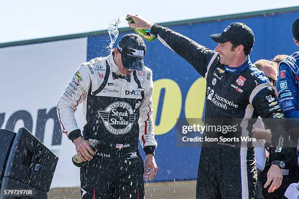 Race winner Graham Rahal gets a Champagne shower from third place finisher Simon Pagenaud following the Honda Indy 200 at Mid-Ohio at the Mid-Ohio...