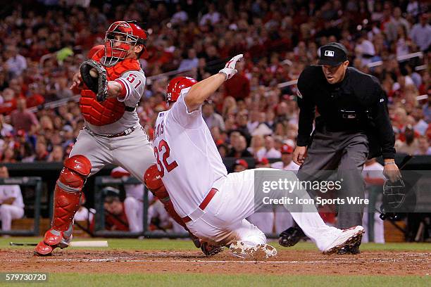 St. Louis Cardinals' Matt Adams safely scores a run as Philadelphia Phillies catcher Carlos Ruiz tries to keep a glove on the ball during the third...