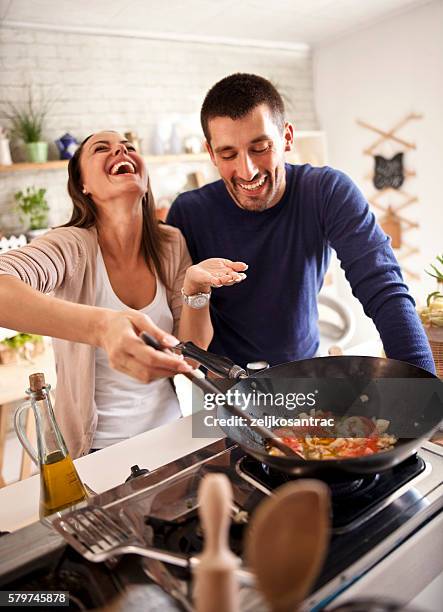 young happy attractive couple at home kitchen tasting - wok stockfoto's en -beelden