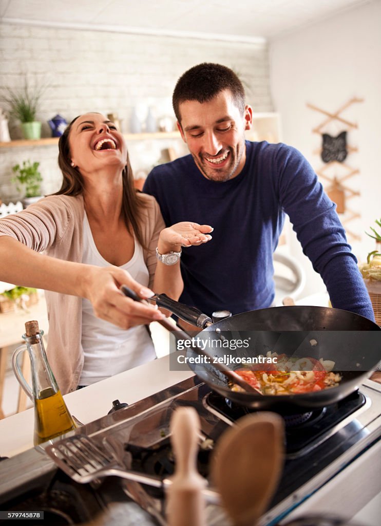 Young happy attractive couple at home kitchen tasting