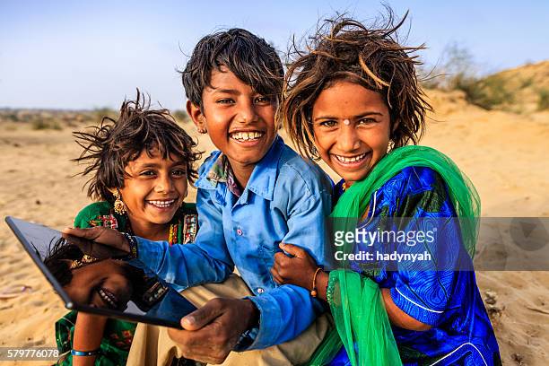 group of happy gypsy indian children using digital tablet, india - local gypsy stock pictures, royalty-free photos & images