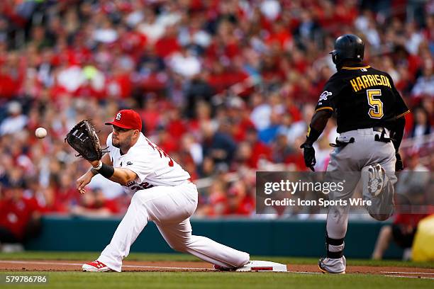 St. Louis Cardinals first baseman Matt Adams makes a play for an out against Pittsburgh Pirates third baseman Josh Harrison during the first inning...